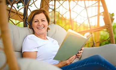 Woman reading book outside comfortably