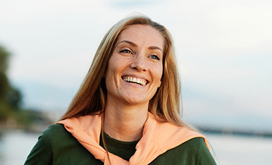 Woman smiling with the beach in the background